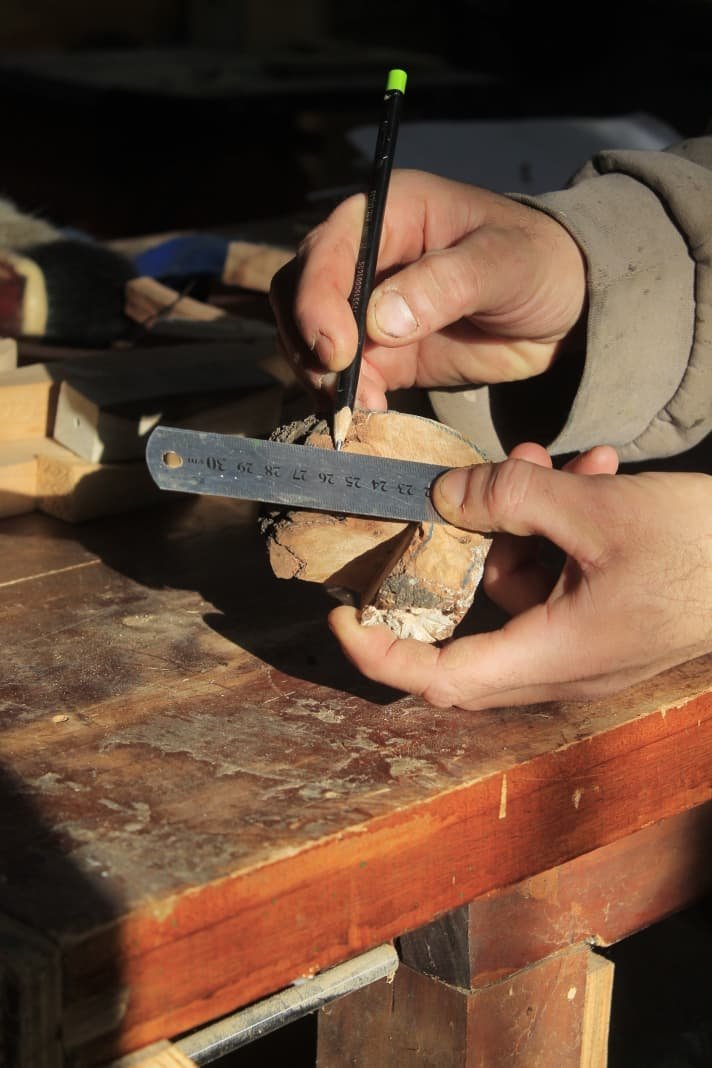 Las manos de Javier midiendo una pieza de madera