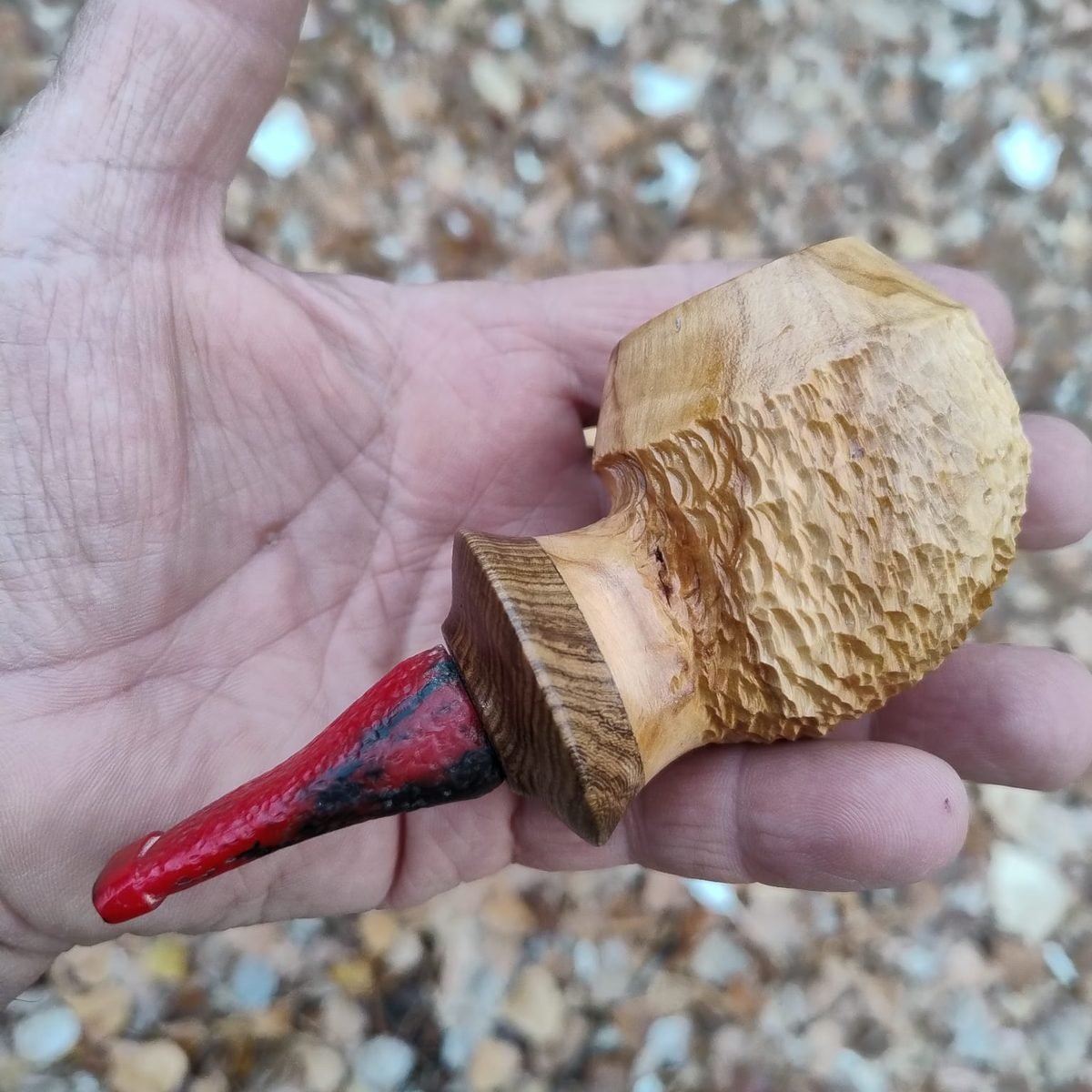 Pipa artesanal en proceso en la mano del artesano